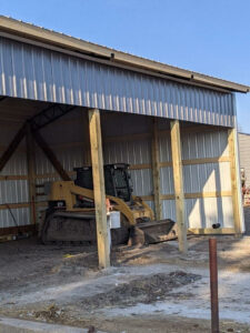 A bulldozer is parked in a metal building.