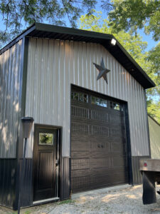 A garage with a black door and a star on it.