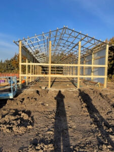 The construction of a steel structure in a field.