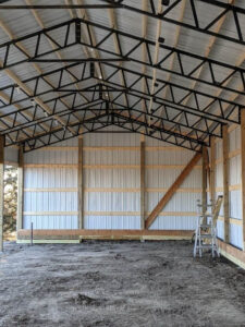 The inside of a barn with a metal roof.