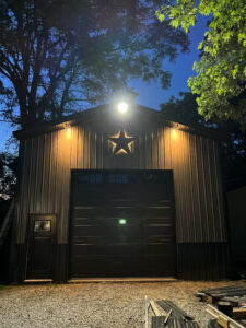 A garage is lit up at night with a star on it.